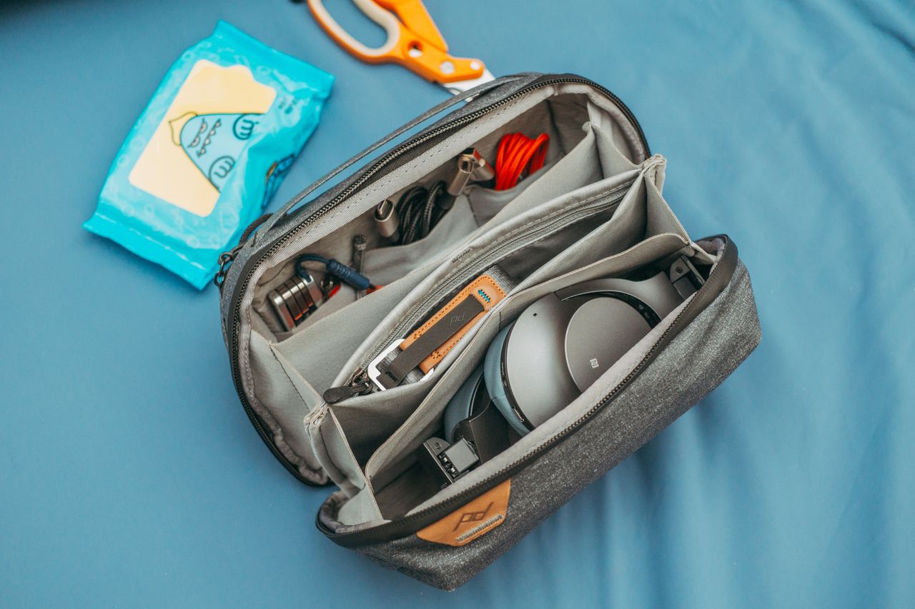 The Art of Drawing Readers In: Your attractive post title goes here A top view of an organized travel tech bag filled with headphones, cables, and wipes.