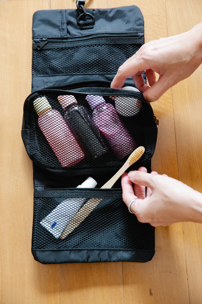 Mastering the First Impression: Your intriguing post title goes here Open toiletry bag with bottles and a bamboo toothbrush on wooden surface.